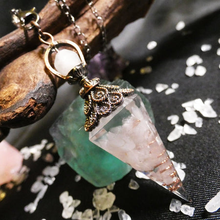 Pendolo in orgonite e quarzo rosa con spirale di rame per divinazione e armonia energetica.