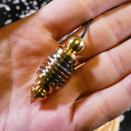 Pendolo divinatorio 7 metalli, utile per meditazione profonda e riequilibrio.