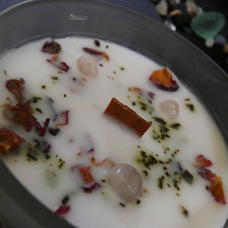 Candela artigianale rosa con quarzo rosa e petali di rosa, ideale per amore e armonia.