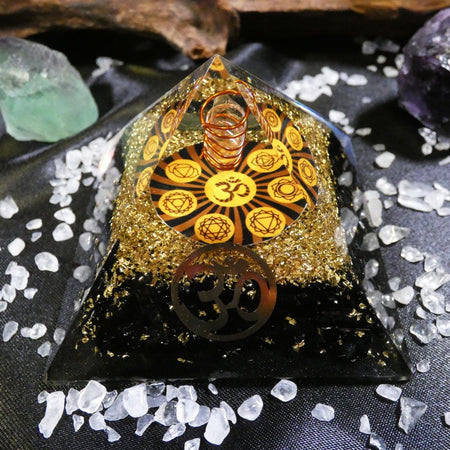 piramide di orgonite con Tormalina Nera e Chakra, ideale per protezione e centratura interiore.