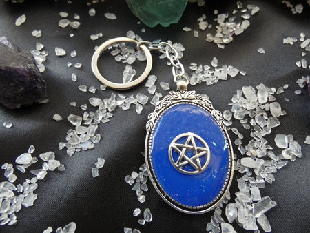Ciondolo Pentacolo blu in resina con cornice metallica decorata, accessorio esoterico elegante.