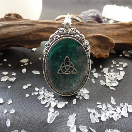 Portachiavi Triquetra celtica in resina verde e metallo, simbolo di protezione e spiritualità.