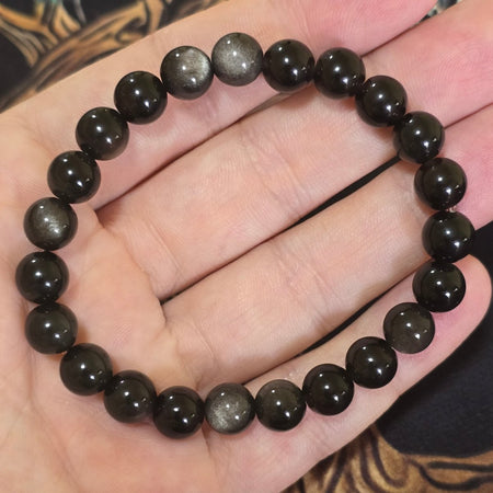 Bracciale in ossidiana argentata 8 mm con riflessi unici, ideale per chi cerca protezione e consapevolezza spirituale.
