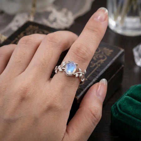 Dettaglio di un anello in adularia e argento indossato, che mostra la lucentezza della pietra e della placcatura in platino.
