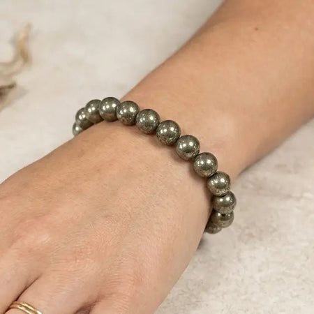 Dettaglio delle sfere in pirite naturale del bracciale indossate su polso.