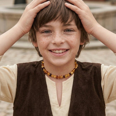 Bambino sorridente che indossa la collana in ambra russa naturale