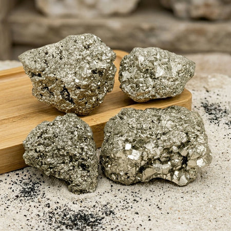 Quattro pietre grezze di pirite dorata, ideali per cristalloterapia e collezionismo di minerali.